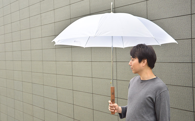 傘をさしている人を横から撮影した写真